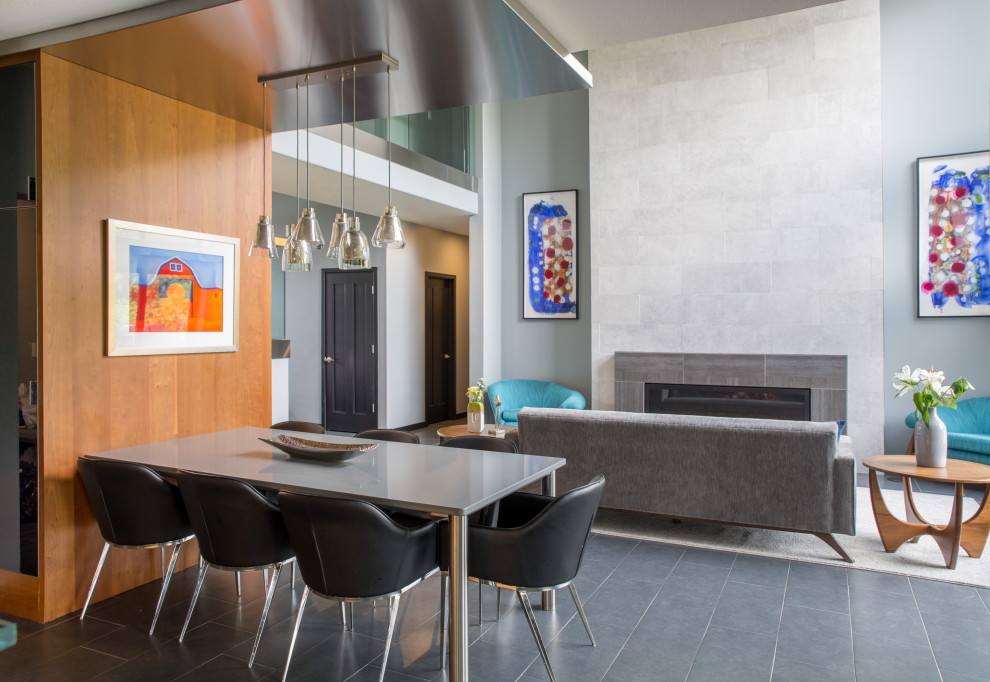 На фото: открытая гостиная комната среднего размера в стиле модернизм с серыми стенами, стандартным камином, полом из сланца, фасадом камина из камня и серым полом