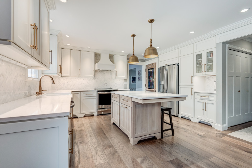 Inspiration for a mid-sized transitional l-shaped light wood floor and brown floor eat-in kitchen remodel in Chicago with a farmhouse sink, shaker cabinets, white cabinets, quartzite countertops, white backsplash, glass tile backsplash, colored appliances, an island and white countertops