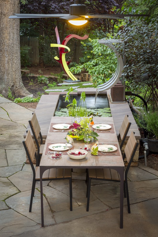 Inspiration for a large contemporary backyard concrete paver patio fountain remodel in DC Metro with a pergola