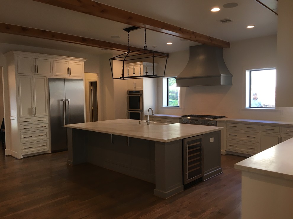 Inspiration for a large transitional u-shaped medium tone wood floor and brown floor open concept kitchen remodel in Houston with a farmhouse sink, shaker cabinets, white cabinets, wood countertops, white backsplash, subway tile backsplash, stainless steel appliances and an island