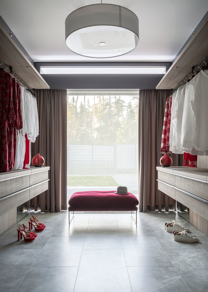 Inspiration for a large contemporary gender-neutral walk-in wardrobe in Moscow with flat-panel cabinets, light wood cabinets, porcelain floors and grey floor.