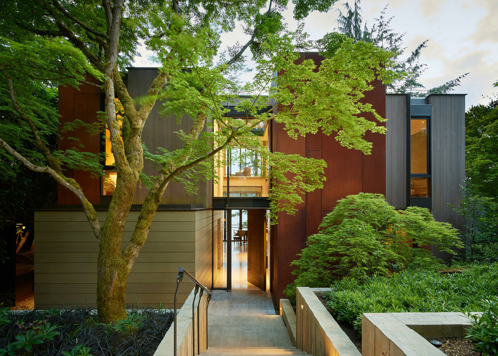 Design ideas for a contemporary two-storey brown house exterior in Seattle with mixed siding and a flat roof.