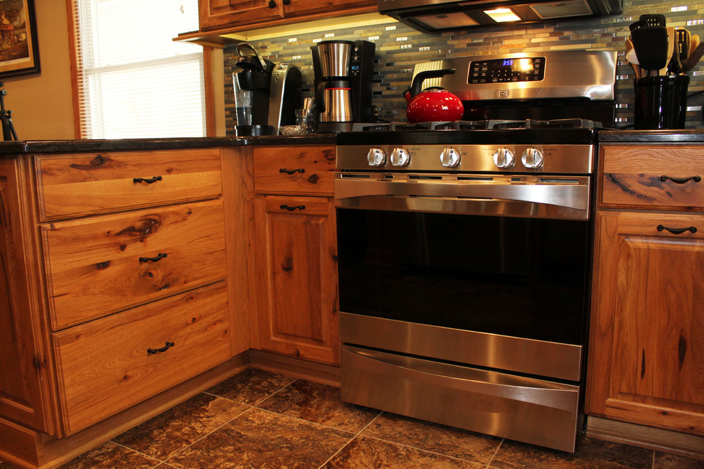 Kitchen - mid-sized rustic u-shaped kitchen idea with raised-panel cabinets, medium tone wood cabinets, quartz countertops, stone tile backsplash and stainless steel appliances