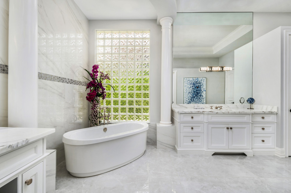 Inspiration för stora klassiska grått en-suite badrum, med möbel-liknande, vita skåp, ett fristående badkar, en kantlös dusch, vit kakel, marmorkakel, grå väggar, marmorgolv, ett integrerad handfat, marmorbänkskiva, vitt golv och dusch med gångjärnsdörr