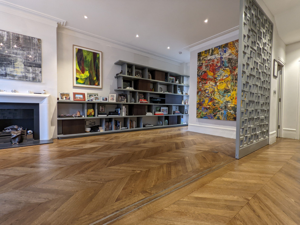 This is an example of a large contemporary open plan living room in London with medium hardwood flooring and brown floors.