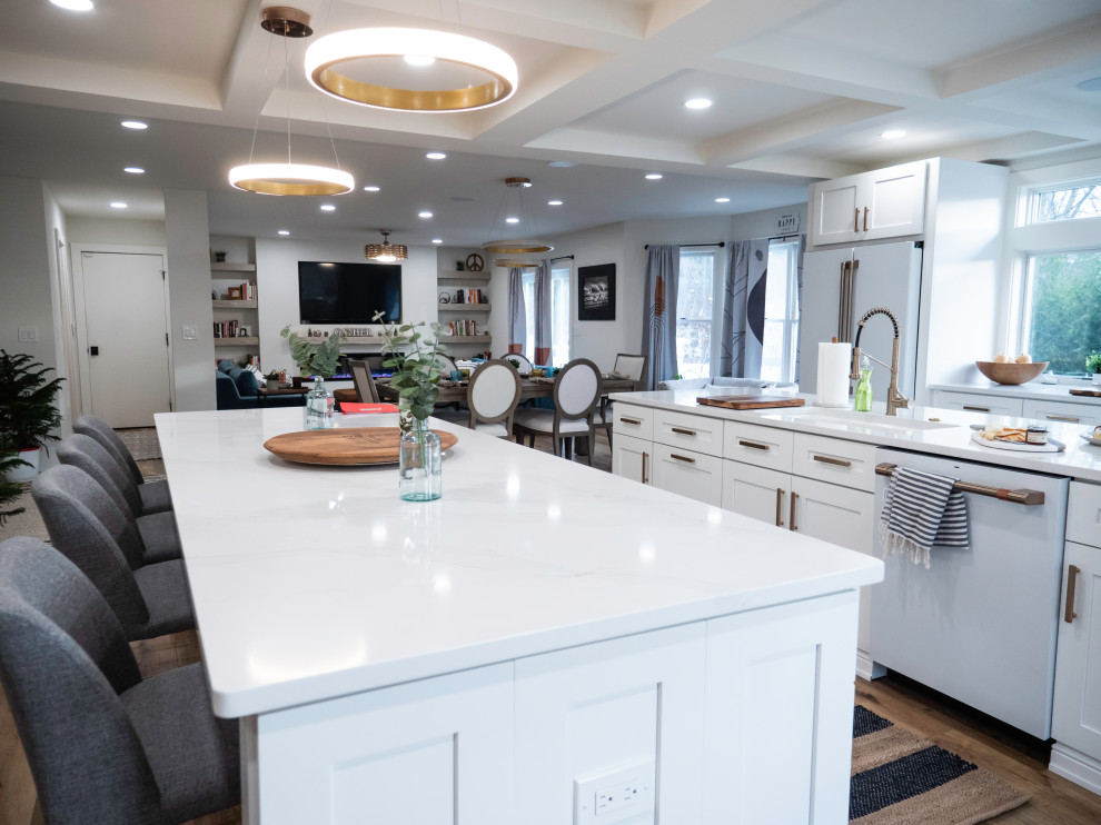 Inspiration for an expansive modern open plan kitchen in Philadelphia with a farmhouse sink, shaker cabinets, white cabinets, wood benchtops, white splashback, engineered quartz splashback, white appliances, laminate floors, multiple islands, brown floor, white benchtop and coffered.