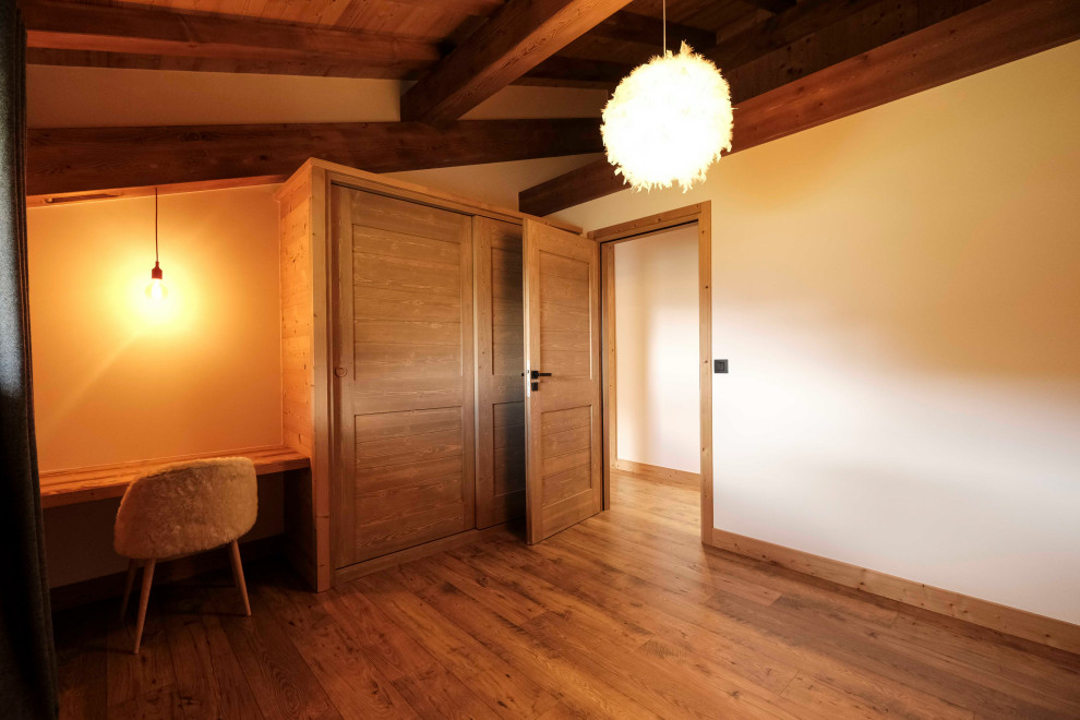 Idée de décoration pour une petite chambre neutre de 4 à 10 ans chalet en bois avec un bureau, un mur blanc, sol en stratifié, un sol marron et un plafond en bois.