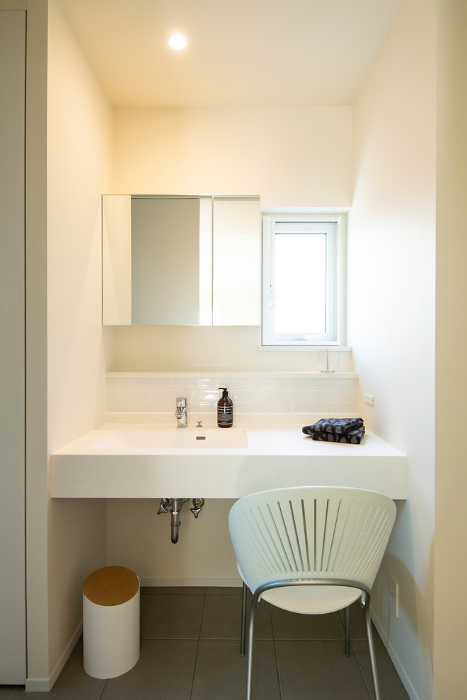Inspiration for a scandinavian powder room in Fukuoka with white walls, an integrated sink and grey floor.
