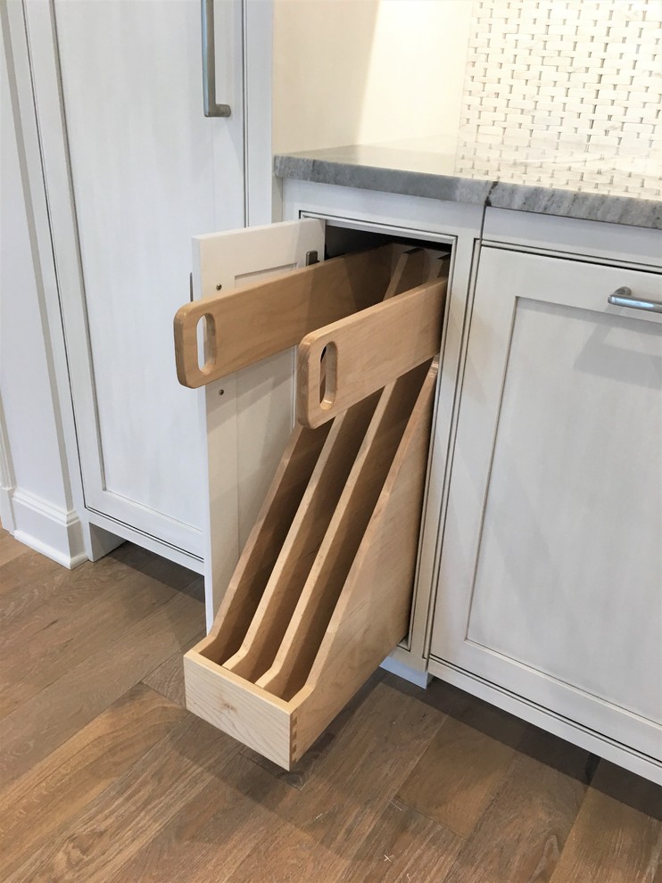 Example of a large transitional l-shaped medium tone wood floor and brown floor eat-in kitchen design with an undermount sink, flat-panel cabinets, gray cabinets, marble countertops, gray backsplash, marble backsplash, paneled appliances and an island