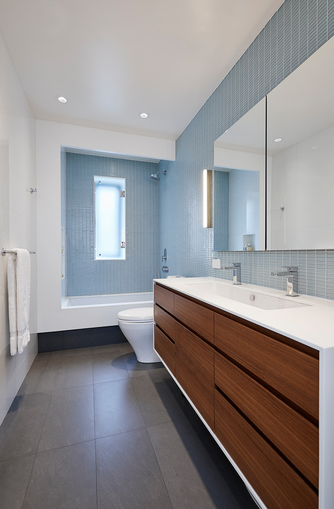 This is an example of a contemporary bathroom in New York with flat-panel cabinets, dark wood cabinets, an undermount tub, a shower/bathtub combo, white walls, an undermount sink, grey floor and an open shower.