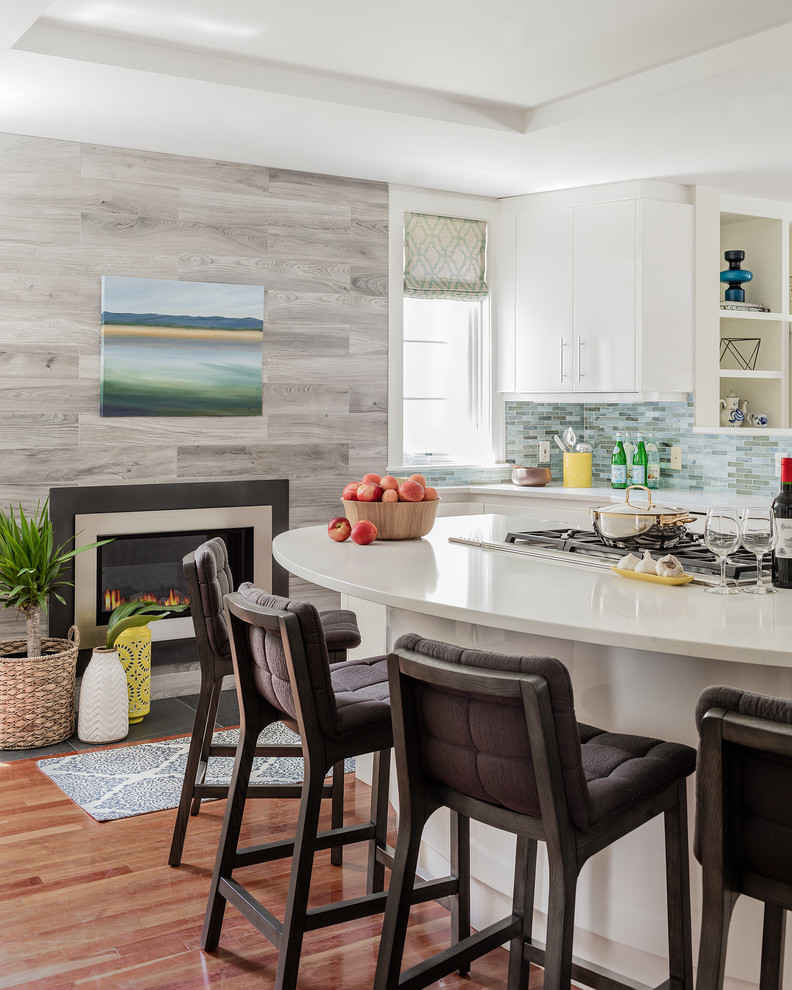 Photo of a large transitional u-shaped eat-in kitchen in Boston with a drop-in sink, flat-panel cabinets, white cabinets, quartz benchtops, multi-coloured splashback, glass tile splashback, stainless steel appliances, medium hardwood floors, with island and brown floor.