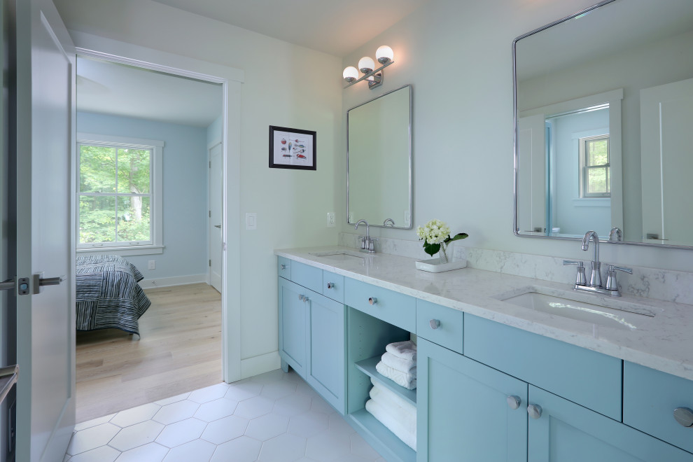 Photo of a mid-sized transitional kids bathroom in Grand Rapids with recessed-panel cabinets, blue cabinets, a shower/bathtub combo, a two-piece toilet, grey walls, porcelain floors, an undermount sink, quartzite benchtops, white floor, a shower curtain, white benchtops, a double vanity and a built-in vanity.