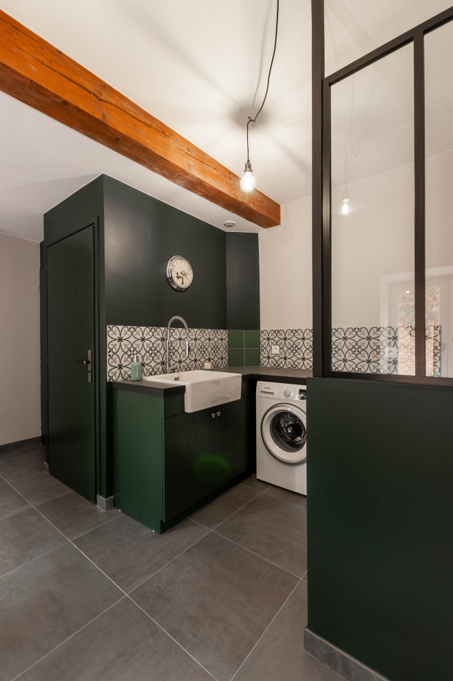 Photo of a large industrial utility room in Lyon with a single-bowl sink, tile benchtops, green walls, ceramic floors, a side-by-side washer and dryer, grey floor and grey benchtop.