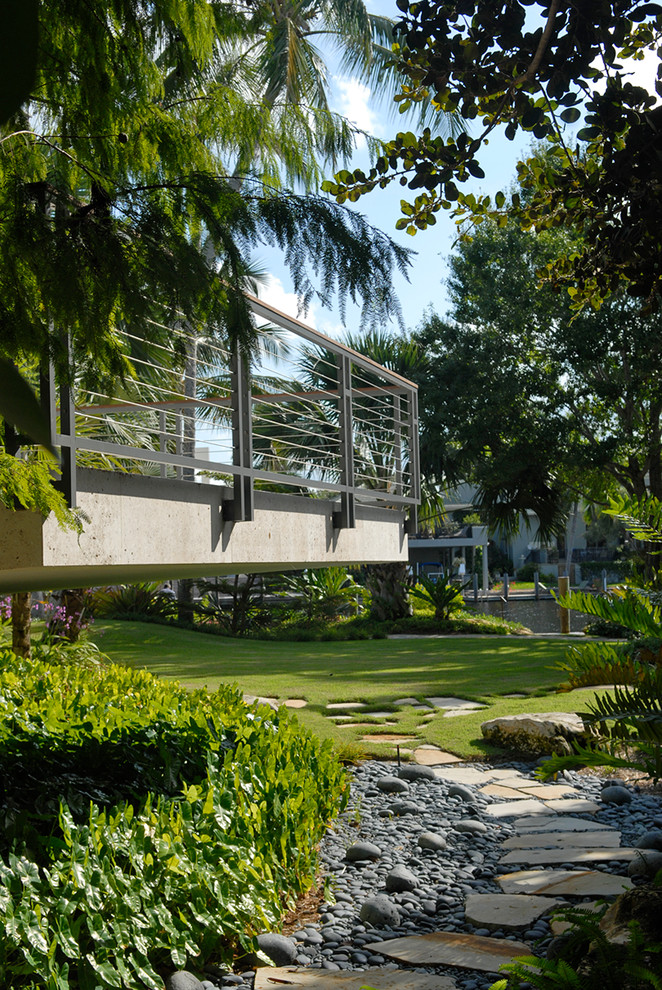 Design ideas for an expansive modern backyard partial sun garden for spring in Miami with a garden path and gravel.