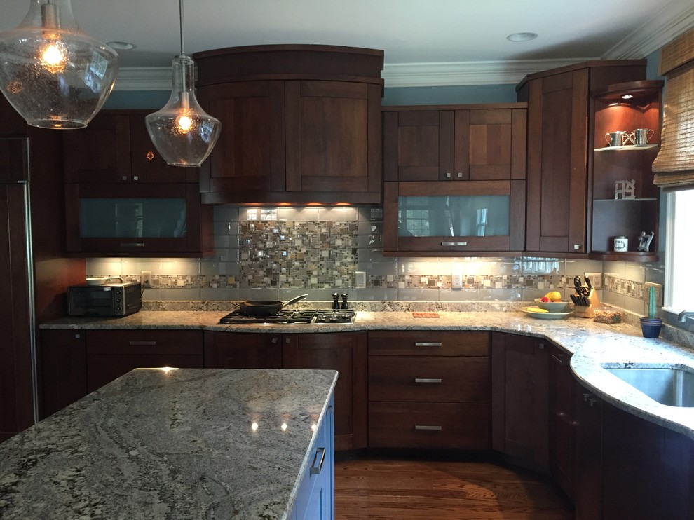 Open concept kitchen - large transitional medium tone wood floor open concept kitchen idea with glass-front cabinets, dark wood cabinets, multicolored backsplash, mosaic tile backsplash, stainless steel appliances and an island