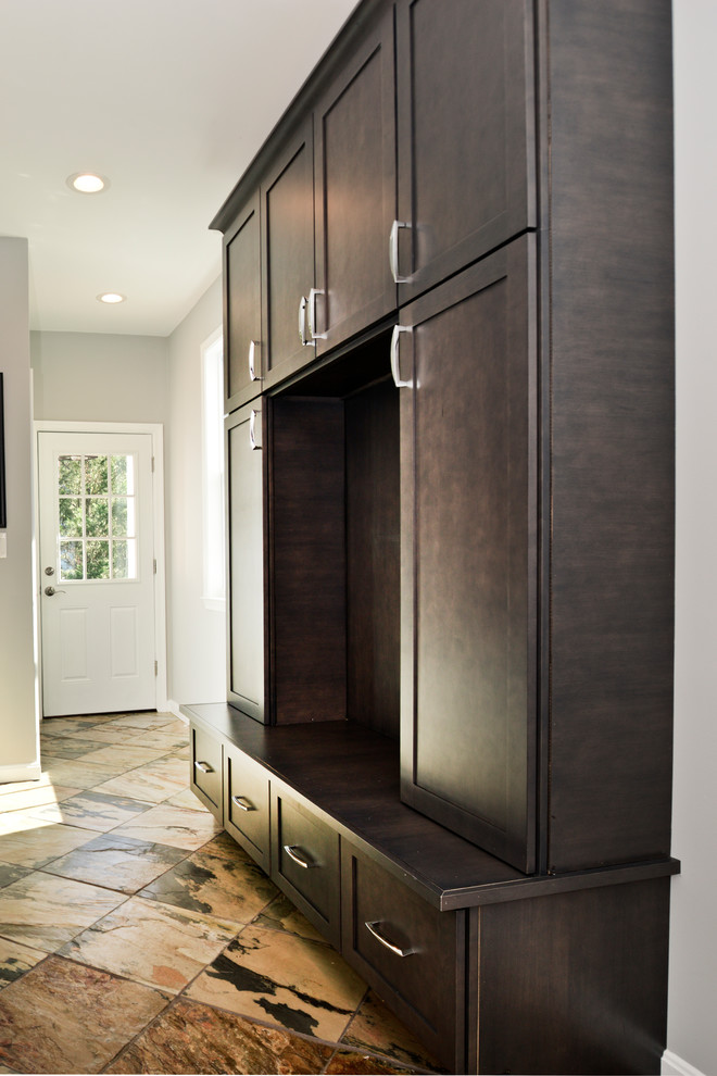 Design ideas for a mid-sized modern gender-neutral walk-in wardrobe in DC Metro with flat-panel cabinets, black cabinets and brown floor.