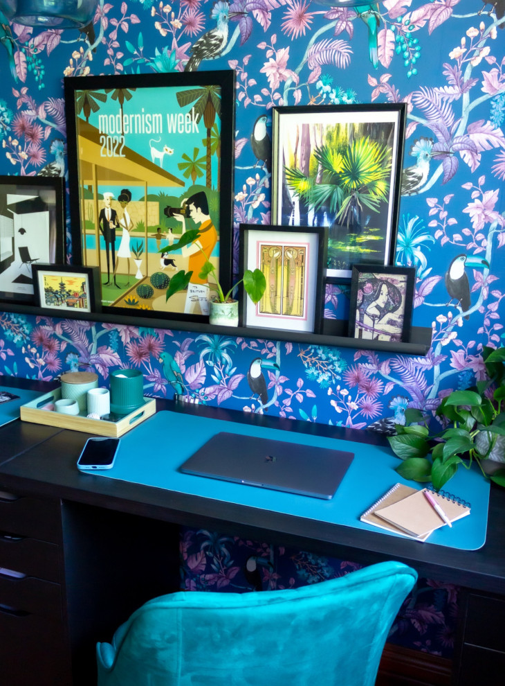 Diseño de sala de manualidades tropical de tamaño medio con paredes azules, suelo de madera en tonos medios y escritorio independiente