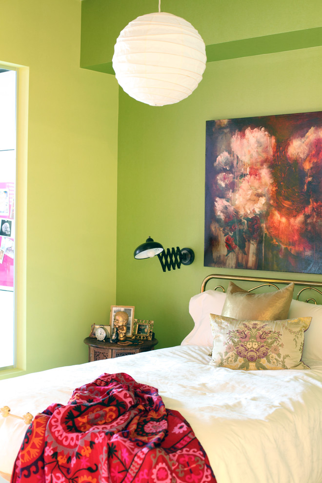 Eclectic bedroom in Vancouver with green walls.