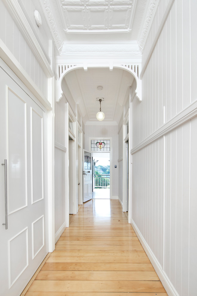 Inspiration for a large transitional hallway in Brisbane with white walls and light hardwood floors.