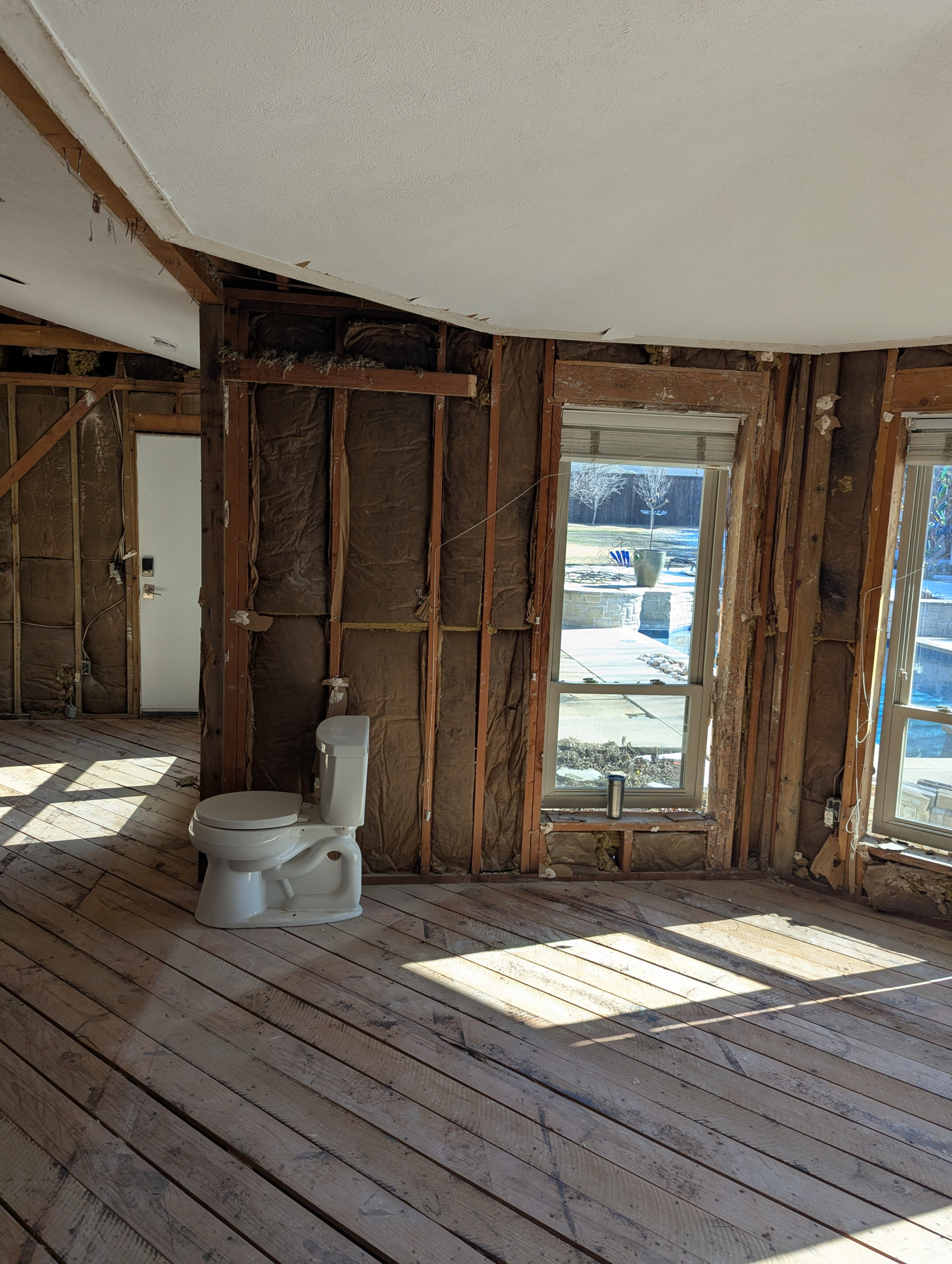 Open Floor Plan : Stripping - Subfloor	A wide-angle view of the demolition phase. The flooring has been cleared to the original planks to check for subfloor stability and levelness across the entire