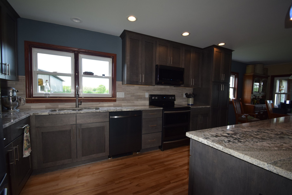 Example of a transitional l-shaped light wood floor eat-in kitchen design with an undermount sink, shaker cabinets, gray cabinets, granite countertops, multicolored backsplash, stone tile backsplash, stainless steel appliances, an island and multicolored countertops