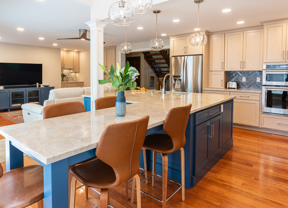 Mid-sized transitional l-shaped medium tone wood floor, brown floor and vaulted ceiling eat-in kitchen photo in Denver with a single-bowl sink, flat-panel cabinets, blue cabinets, quartzite countertops, blue backsplash, porcelain backsplash, stainless steel appliances, an island and beige countertops