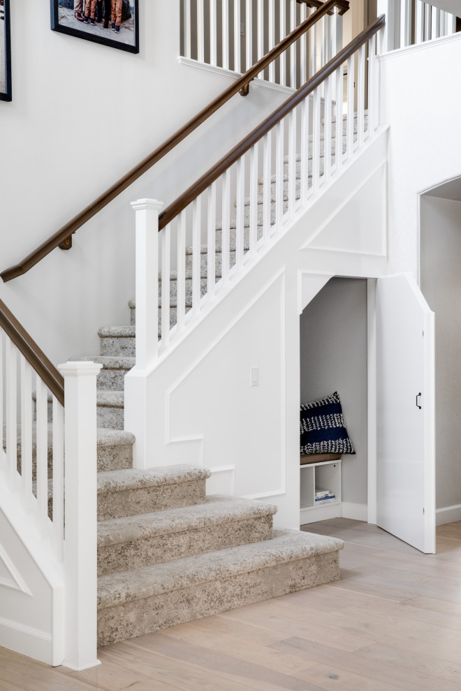 Photo of a medium sized classic carpeted l-shaped wood railing staircase in Orange County with carpeted risers.