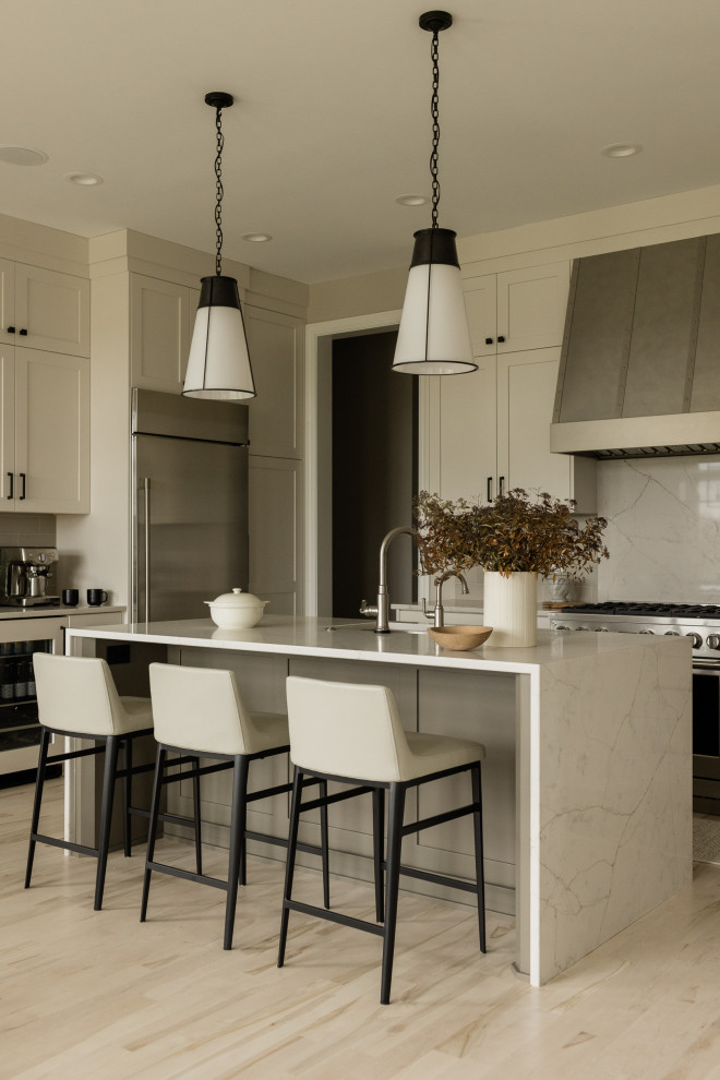 Eat-in kitchen - small transitional u-shaped light wood floor eat-in kitchen idea in Other with an undermount sink, recessed-panel cabinets, beige cabinets, quartz countertops, gray backsplash, ceramic backsplash, stainless steel appliances, an island and white countertops