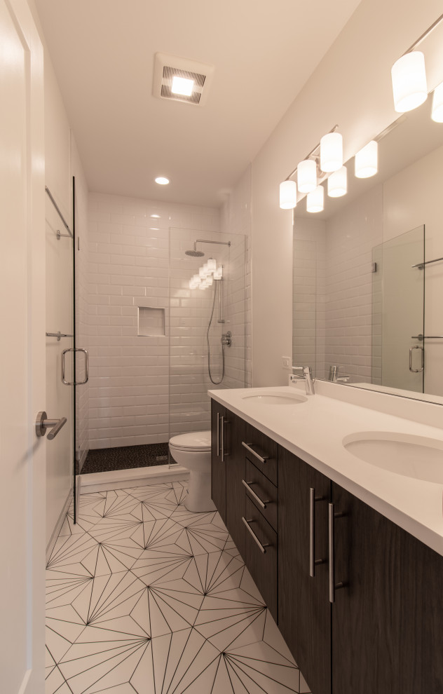 Exempel på ett mellanstort modernt vit vitt en-suite badrum, med släta luckor, bruna skåp, våtrum, en toalettstol med separat cisternkåpa, vit kakel, keramikplattor, vita väggar, klinkergolv i porslin, ett undermonterad handfat, bänkskiva i kvarts, flerfärgat golv och dusch med gångjärnsdörr