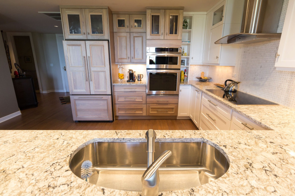 Large transitional u-shaped brown floor and medium tone wood floor open concept kitchen photo in Denver with an undermount sink, shaker cabinets, white cabinets, granite countertops, white backsplash, mosaic tile backsplash, stainless steel appliances and a peninsula