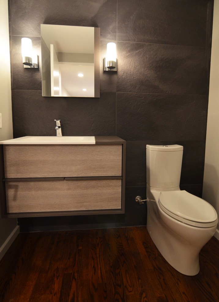Design ideas for a small modern powder room in Other with flat-panel cabinets, grey cabinets, a two-piece toilet, porcelain tile, black walls, an integrated sink, engineered quartz benchtops and gray tile.