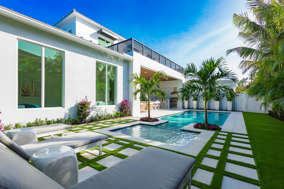 Inspiration for a contemporary backyard rectangular lap pool in Miami with a hot tub and concrete pavers.