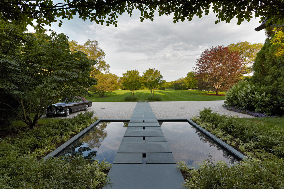 Design ideas for a contemporary partial sun garden in New York with a water feature and gravel.