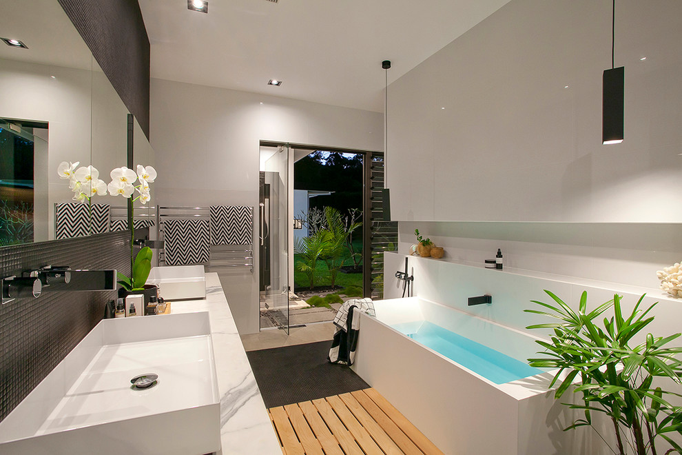 Inspiration for a modern master bathroom in Sunshine Coast with a freestanding tub, black tile, mosaic tile, grey walls, a vessel sink and grey benchtops.