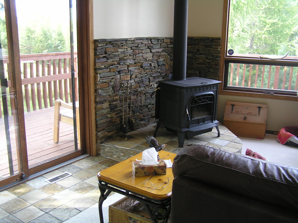 Small mountain style open concept slate floor home design photo in Vancouver with a corner fireplace and a stone fireplace