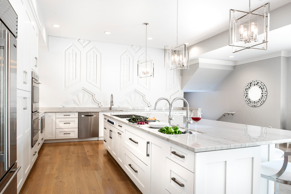 Open concept kitchen - large transitional medium tone wood floor and brown floor open concept kitchen idea with an undermount sink, recessed-panel cabinets, white cabinets, quartzite countertops, brown backsplash, ceramic backsplash, stainless steel appliances, an island and white countertops