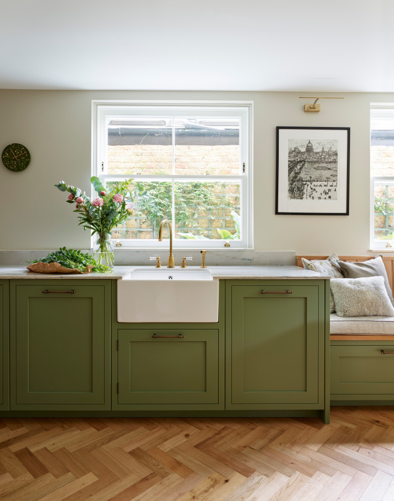 Photo of a large traditional u-shaped eat-in kitchen in Gloucestershire with shaker cabinets, green cabinets, quartzite benchtops, no island, multi-coloured benchtop, a farmhouse sink, white splashback, ceramic splashback, stainless steel appliances, medium hardwood floors and brown floor.