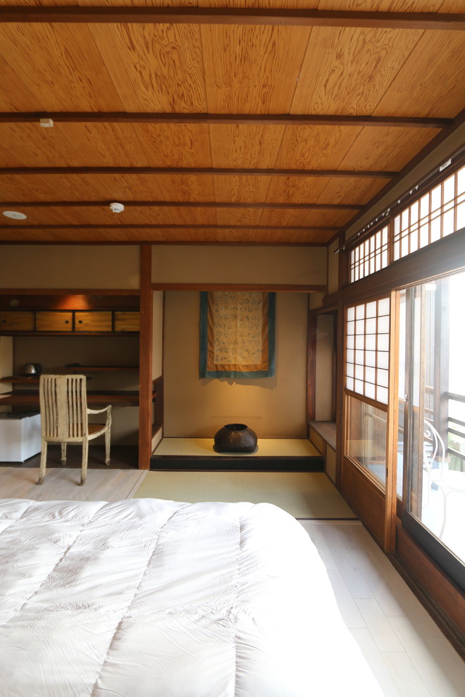 Design ideas for a mid-sized asian guest bedroom in Kyoto with beige walls and light hardwood floors.