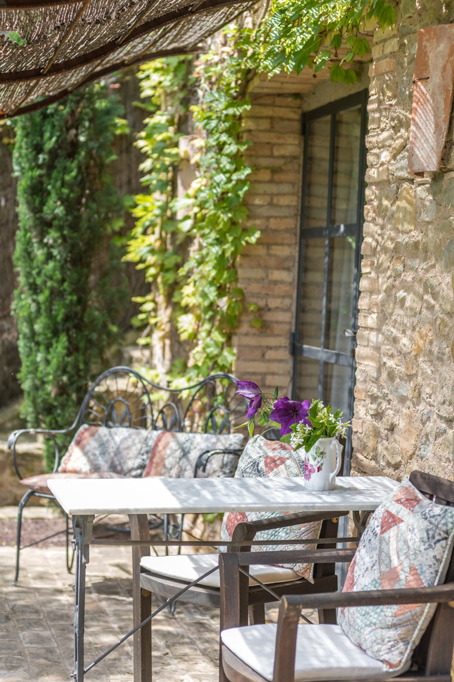Ejemplo de terraza rústica de tamaño medio en patio trasero con toldo