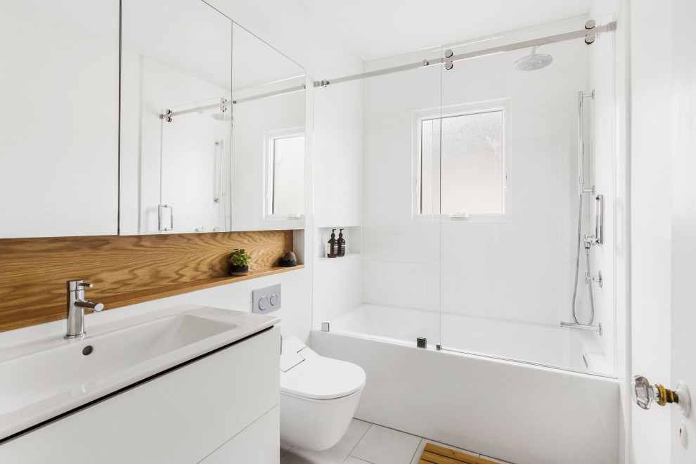 Inspiration for a contemporary bathroom in Other with flat-panel cabinets, white cabinets, an alcove tub, a shower/bathtub combo, white tile, a console sink, white floor, white benchtops, a single vanity and a floating vanity.