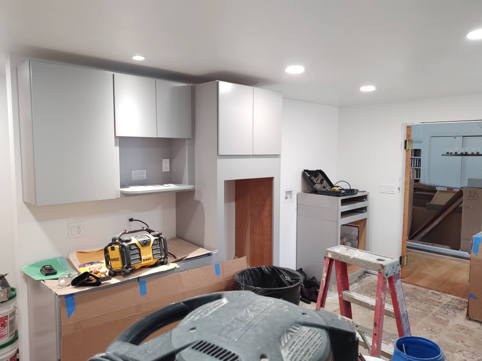 Inspiration for a mid-sized enclosed kitchen remodel with flat-panel cabinets, gray cabinets and a peninsula