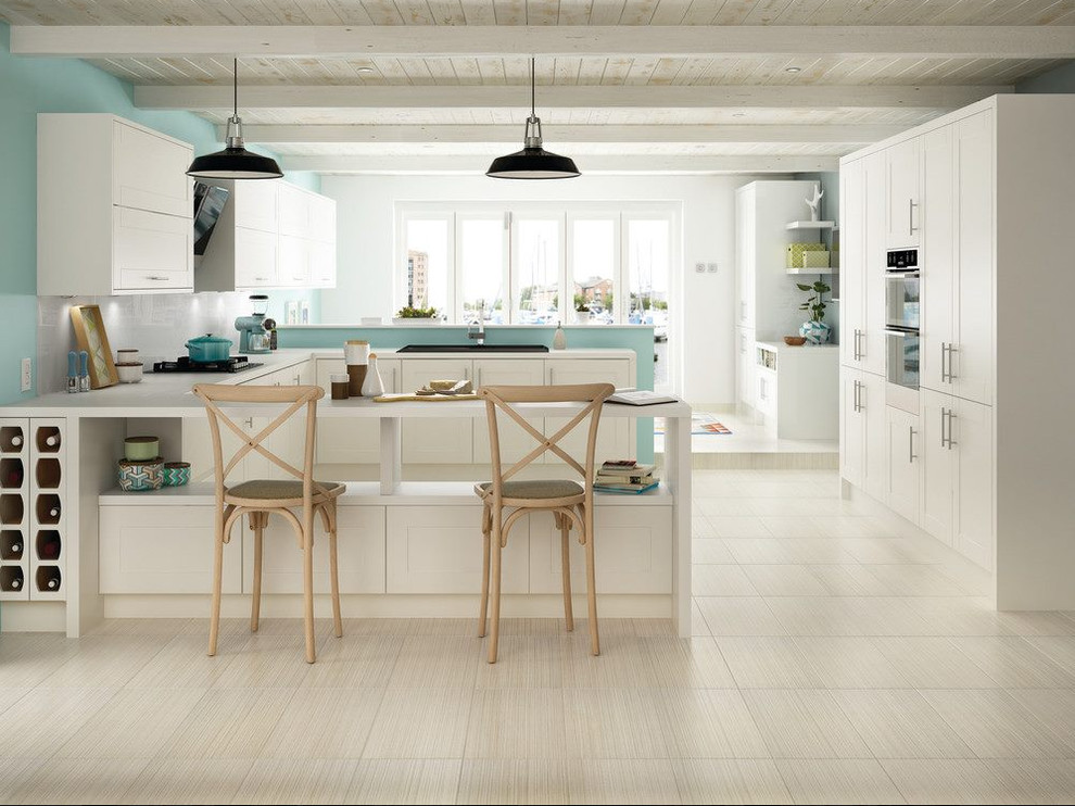 Mid-sized transitional u-shaped vinyl floor eat-in kitchen photo in Indianapolis with a drop-in sink, flat-panel cabinets, white cabinets, solid surface countertops, gray backsplash, paneled appliances and a peninsula
