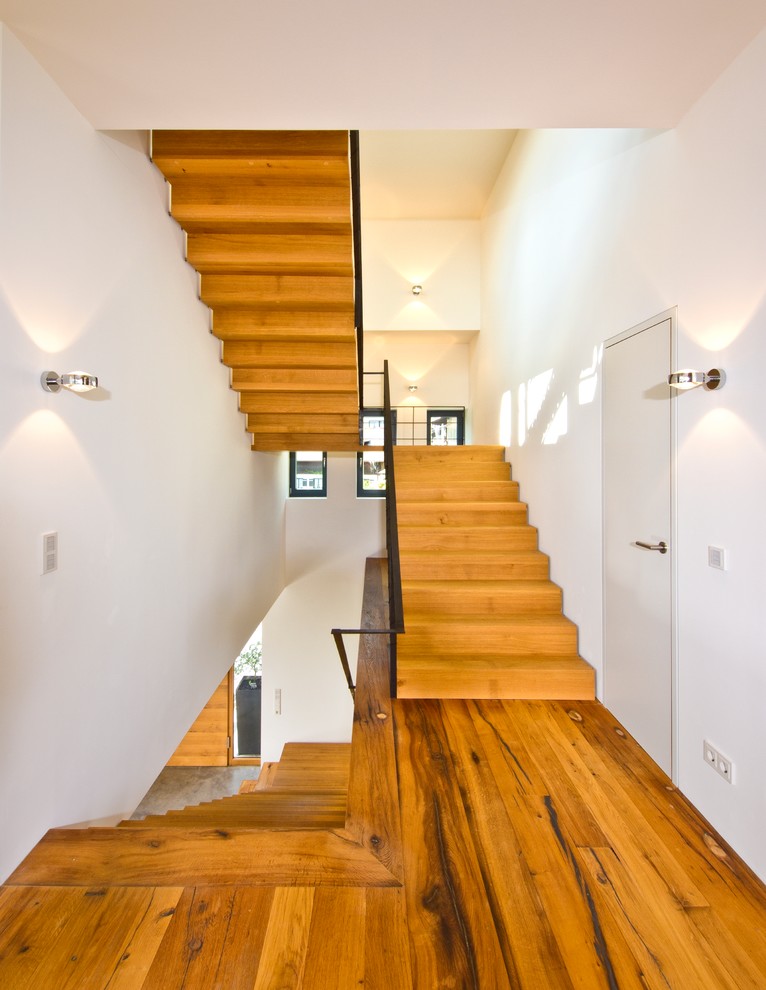 Große Moderne Holztreppe in U-Form mit Holz-Setzstufen in München