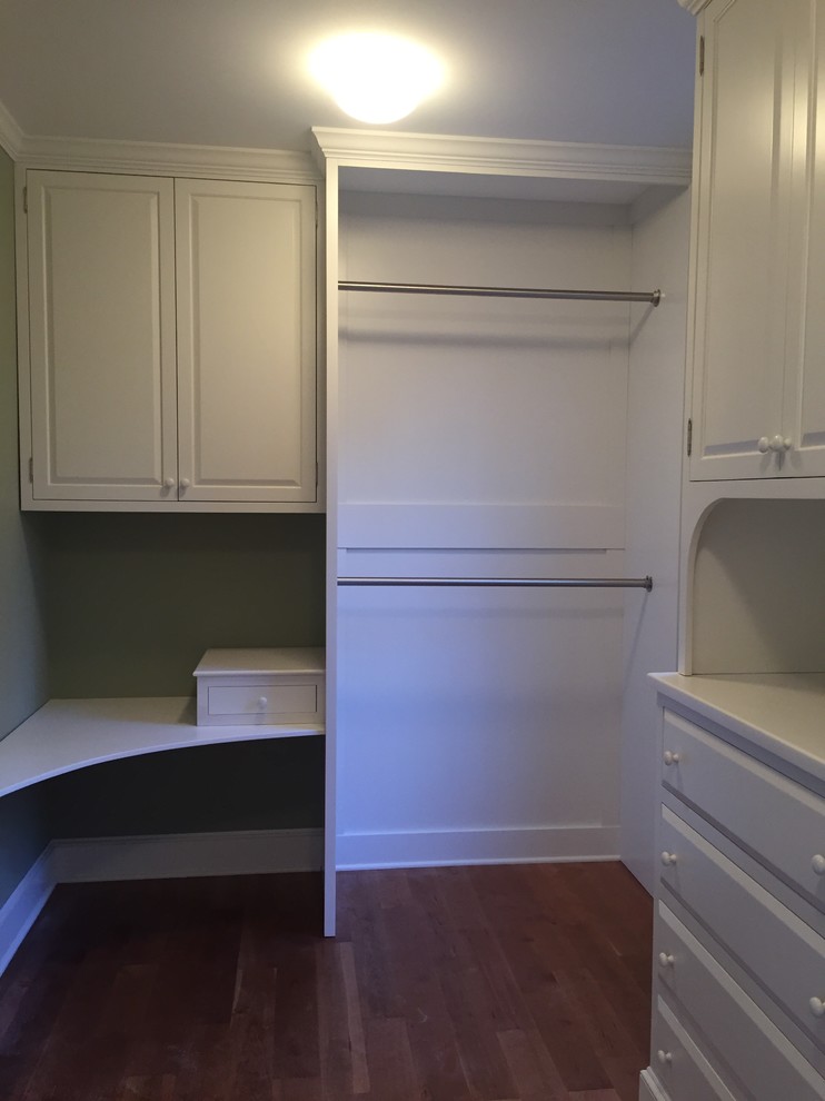 Inspiration for a mid-sized traditional gender-neutral walk-in wardrobe in Bridgeport with raised-panel cabinets, white cabinets, medium hardwood floors and brown floor.