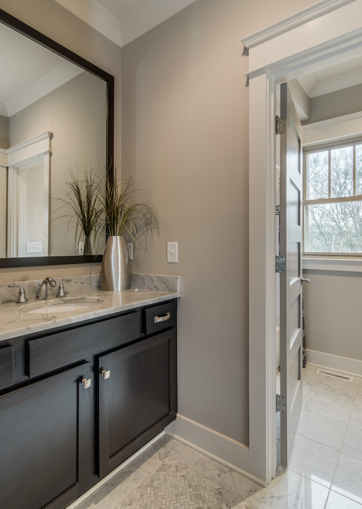 Mid-sized transitional bathroom in Nashville with an undermount sink, shaker cabinets, dark wood cabinets, marble benchtops, an alcove tub, an alcove shower, a two-piece toilet, white tile, stone tile, grey walls and marble floors.