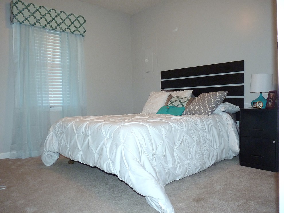 This is an example of a small modern guest bedroom in Raleigh with grey walls, carpet and no fireplace.
