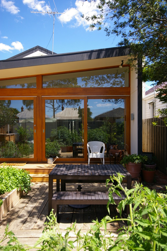 Mid-sized contemporary backyard verandah in Melbourne with a container garden, decking and a roof extension.