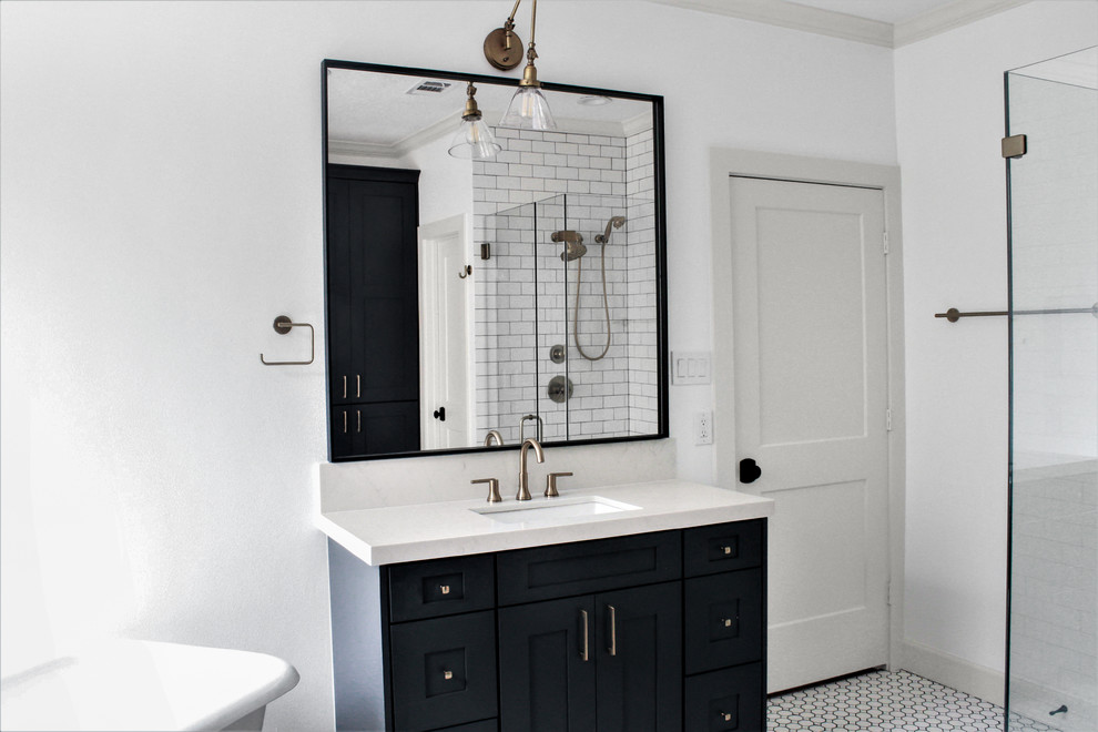 Inspiration for a mid-sized industrial master bathroom in Houston with recessed-panel cabinets, dark wood cabinets, a freestanding tub, a curbless shower, a two-piece toilet, white tile, subway tile, white walls, porcelain floors, an undermount sink, engineered quartz benchtops, white floor, a hinged shower door and white benchtops.
