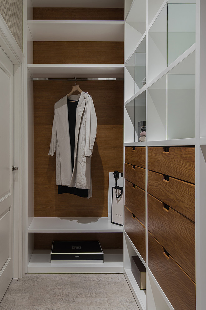 Mid-sized contemporary gender-neutral walk-in wardrobe in Moscow with flat-panel cabinets, cork floors, medium wood cabinets and beige floor.