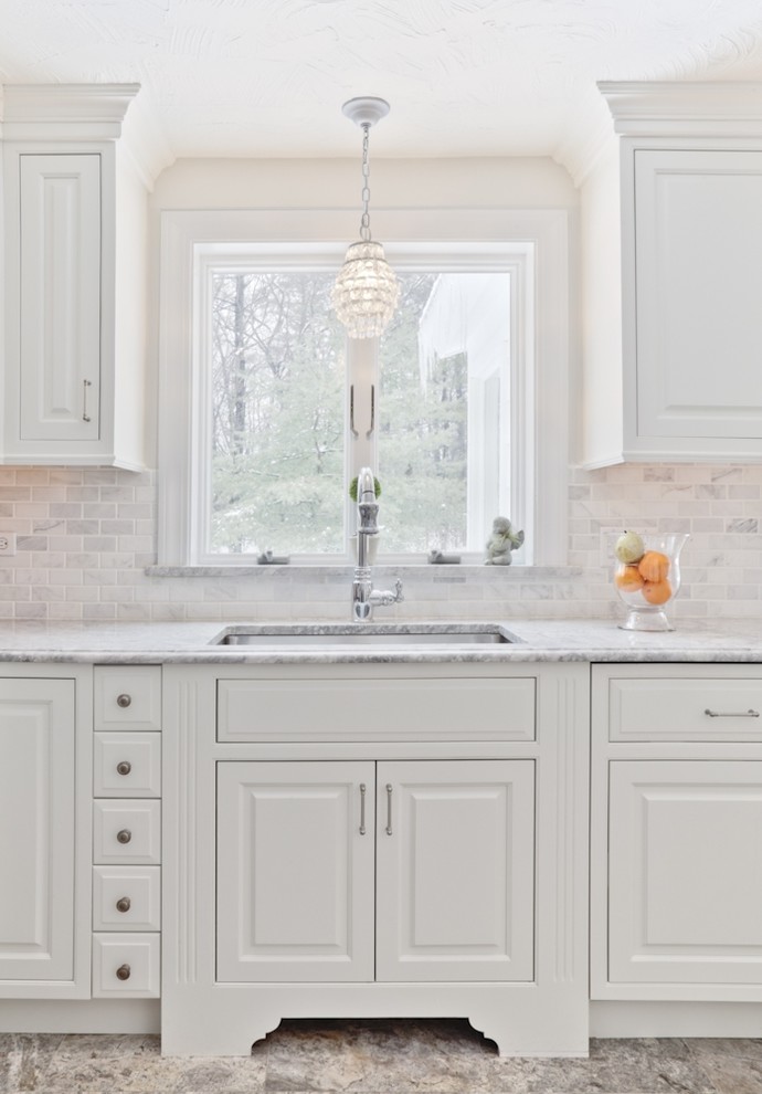 Inspiration for a traditional kitchen in Boston with a single-bowl sink, raised-panel cabinets, white cabinets, white splashback and marble splashback.